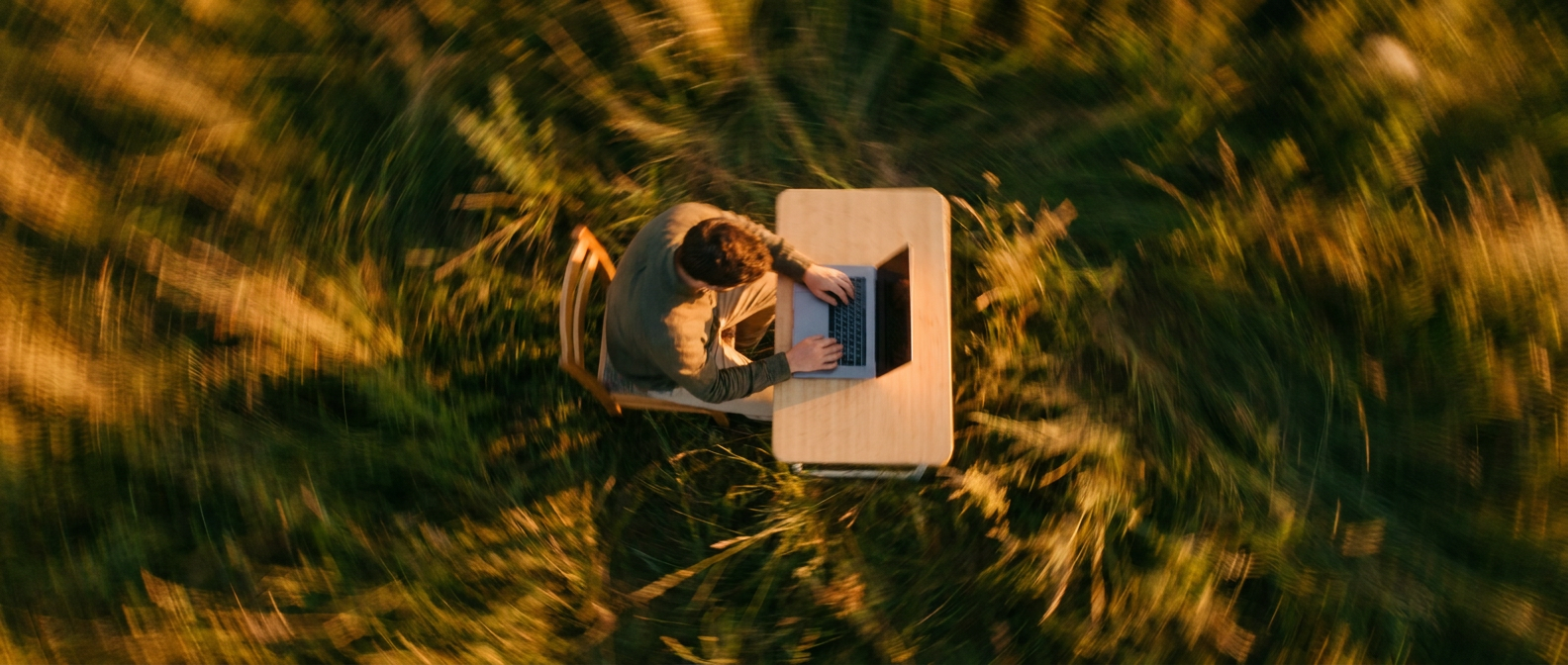 Working at a desk in a golden field, seen from above